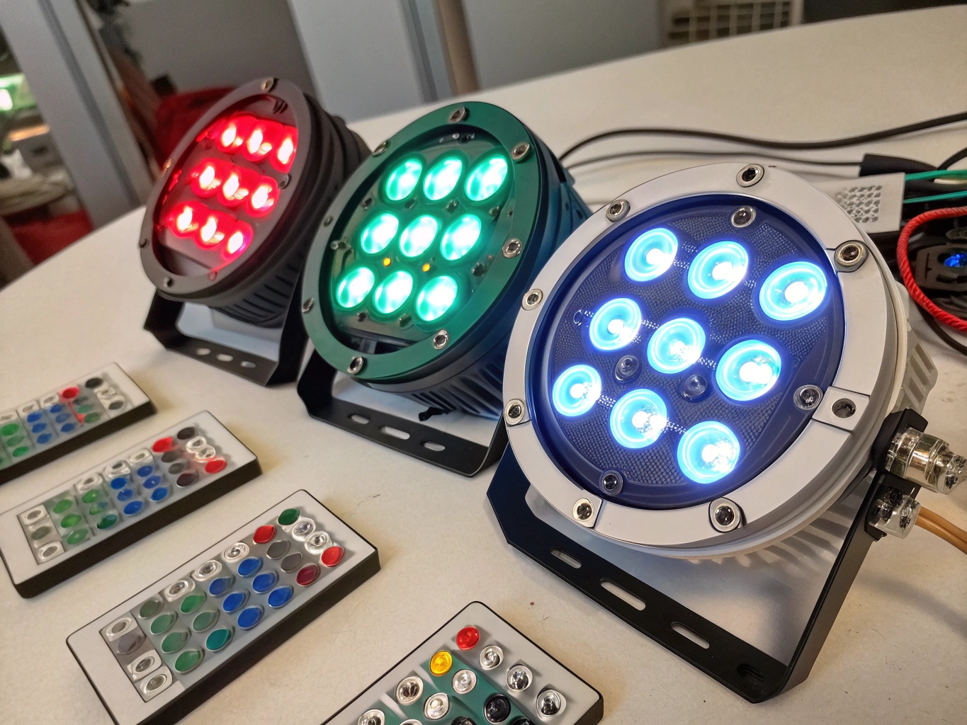 A lighting console showing faders for Red, Green, Blue, Warm White, and Cool White.
